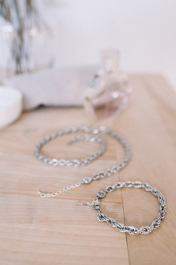 Flat lay fashion photoshoot Bijoux Pépine’s hypoallergenic stainless steel signature chain bracelet and necklace