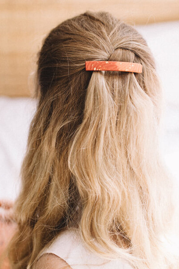 blonde model wearing Boeme by Bijoux Pépine, handmade coral red hair barrette with 24 karat gold leaf 
