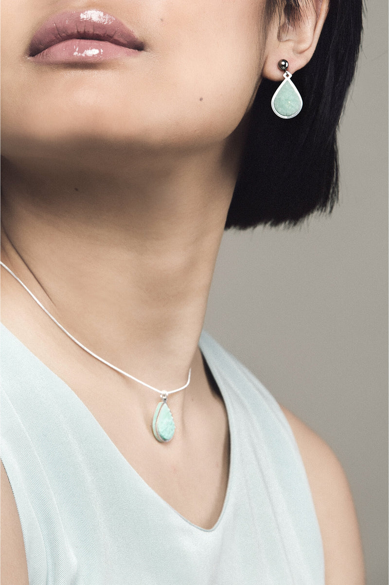 Fashion model woman wearing Candide jewelry set parure with earrings studs and teardrop adjustable length necklace in green aqua mint color resin and hypoallergenic stainless steel