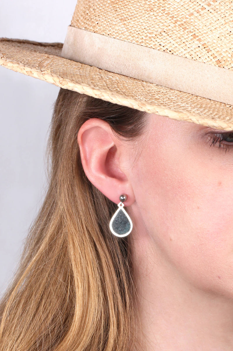 model wearing Candide teardrop studs in forest green resin and hypoallergenic stainless steel