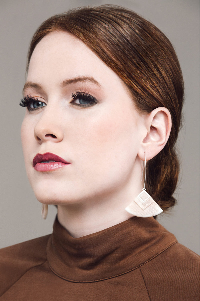 redhead model wearing Cléopâtre statement earrings, in beige resin and hypoallergenic stainless steel