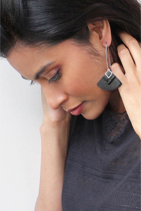 dark-haired model wearing Cléopâtre statement earrings, in black resin and hypoallergenic stainless steel