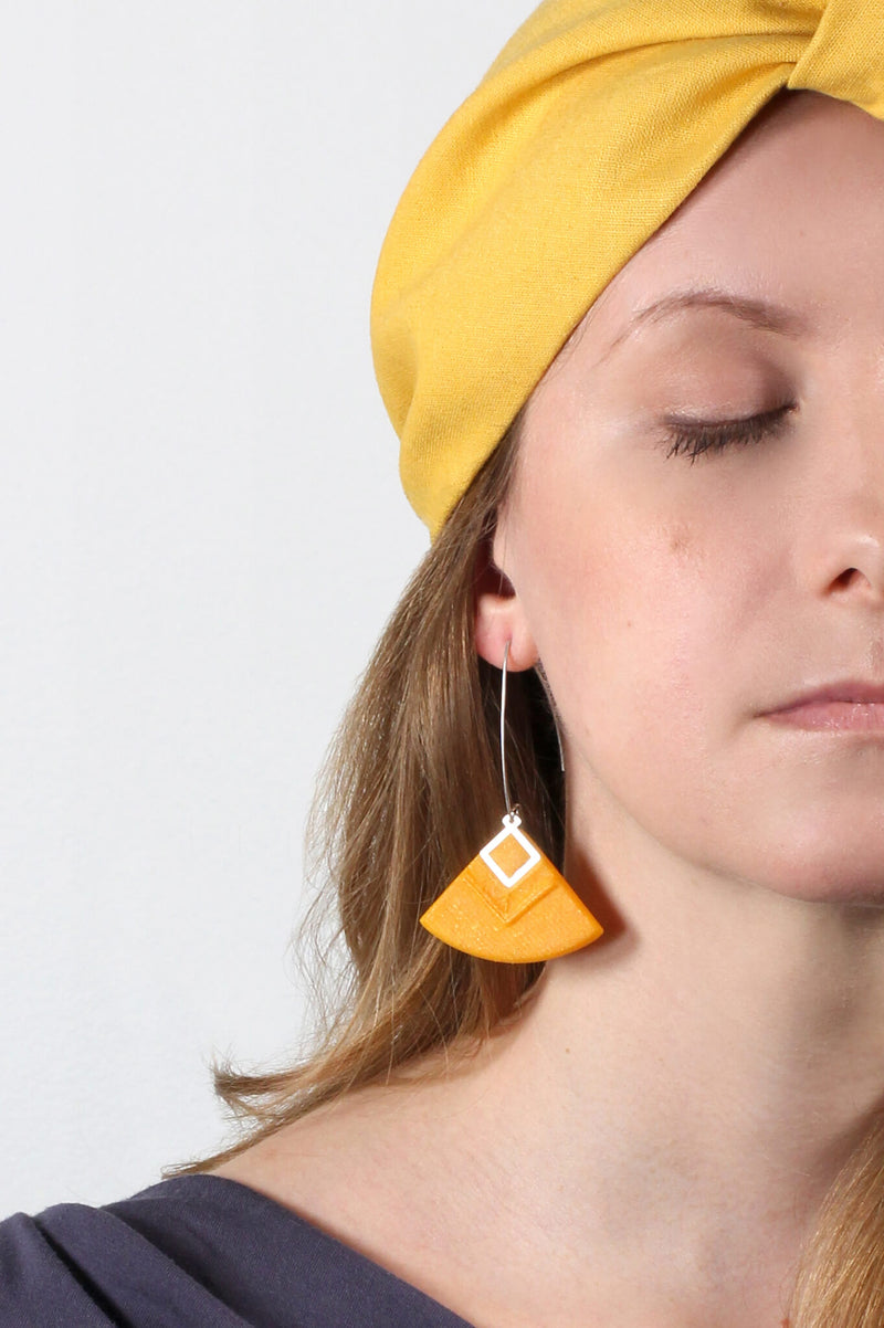 blonde model wearing Cléopâtre statement earrings, in golden-yellow resin and hypoallergenic stainless steel