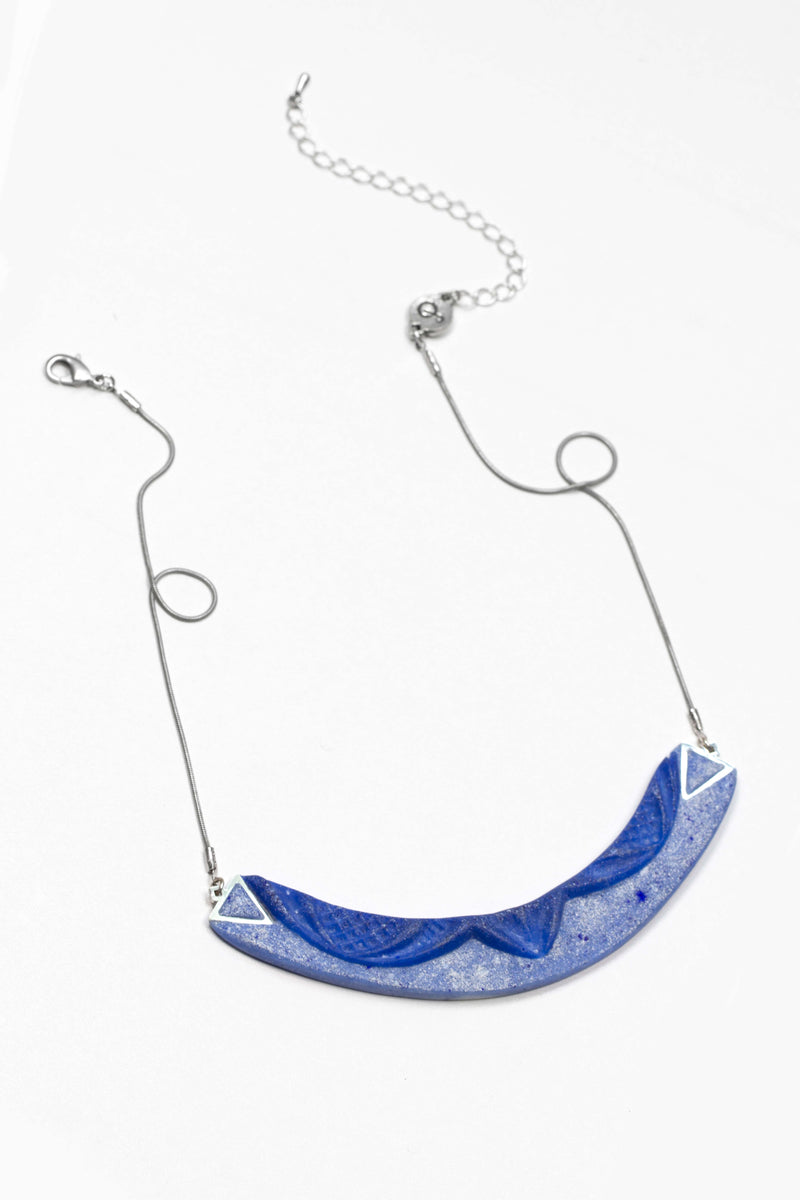 dark-haired model wearing Couronne, handmade necklace in indigo blue resin and hypoallergenic stainless steel