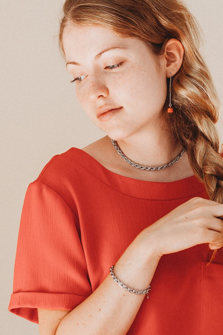 photoshoot de mode : modèle féminin aux cheveux blonds portant un bracelet et un collier en acier inoxydable hypoallergénique de Bijoux Pépine.