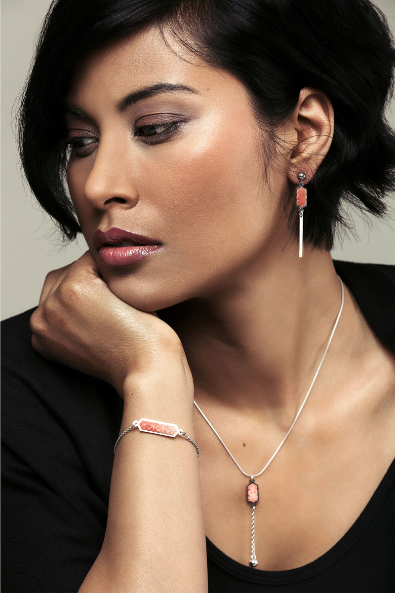 model wearing Bijoux Pépine’s handmade Nova stud earrings in coral red