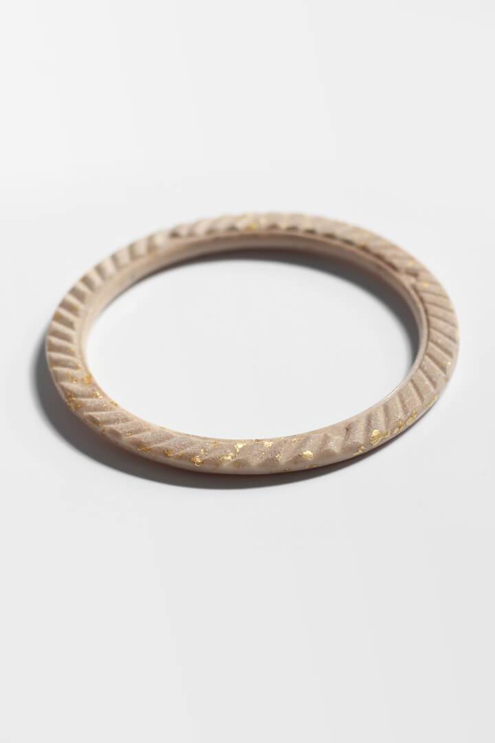 Bracelet Ouroboros, bracelet bangle fabriqué à la main par Bijoux Pépine en résine écologique de couleur beige et feuille d'or 24 carats, procédé artisanal.