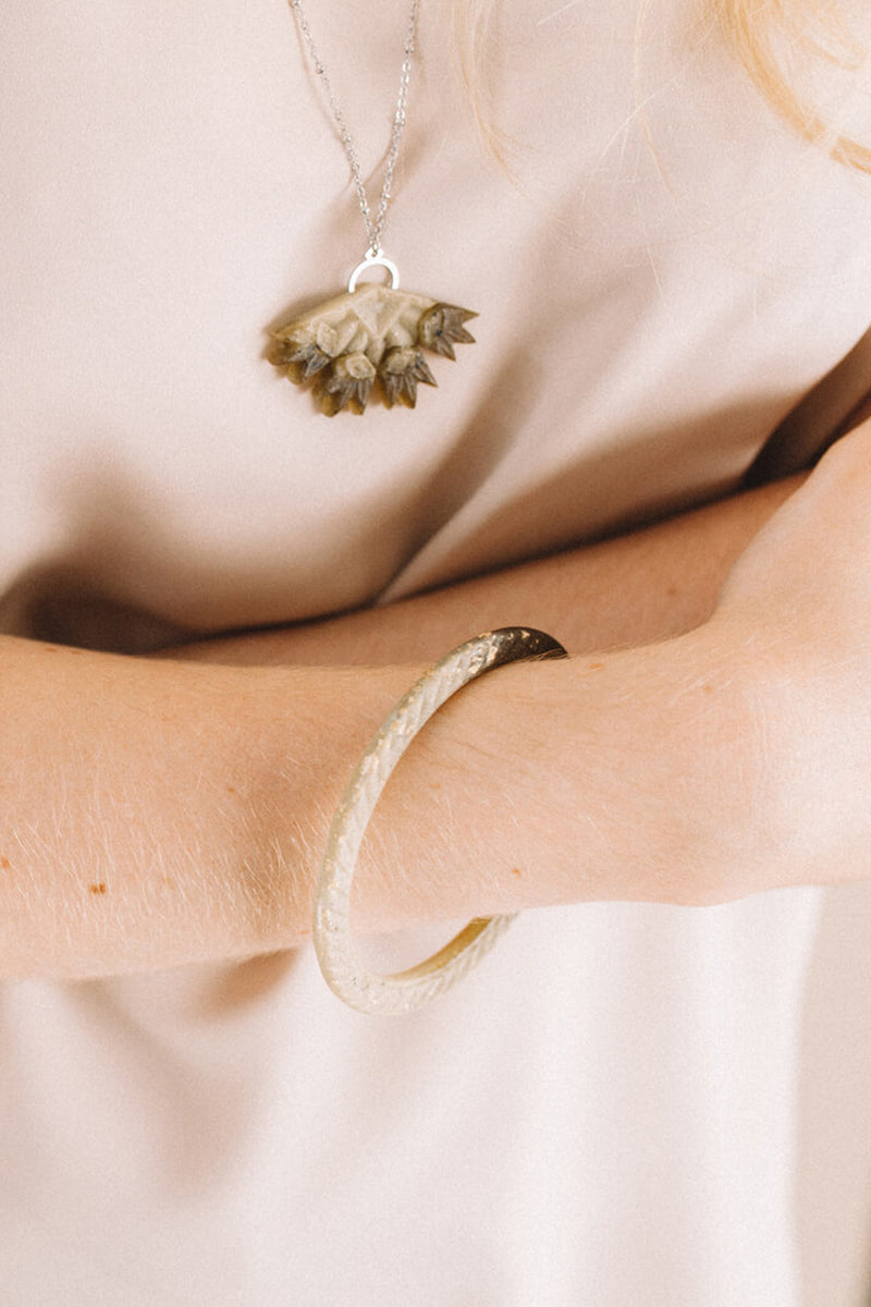 model wearing designer Bijoux Pépine's Ouroboros bangle bracelet and Flabellum necklace
