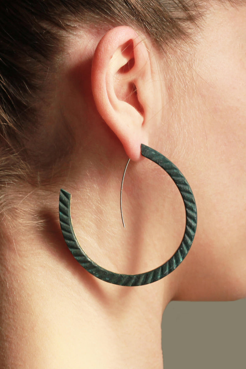 fashion model wearing Bijoux Pépine's handmade Ouroboros hoops in forest green