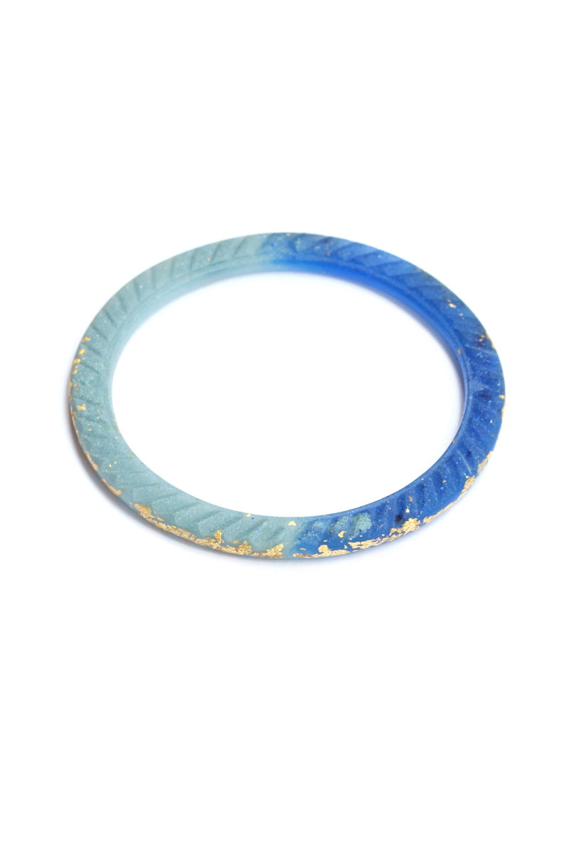 Bracelet Ouroboros, bracelet bangle fabriqué à la main par Bijoux Pépine en résine écologique de couleur bleu indigo et feuille d'or 24 carats, procédé artisanal.