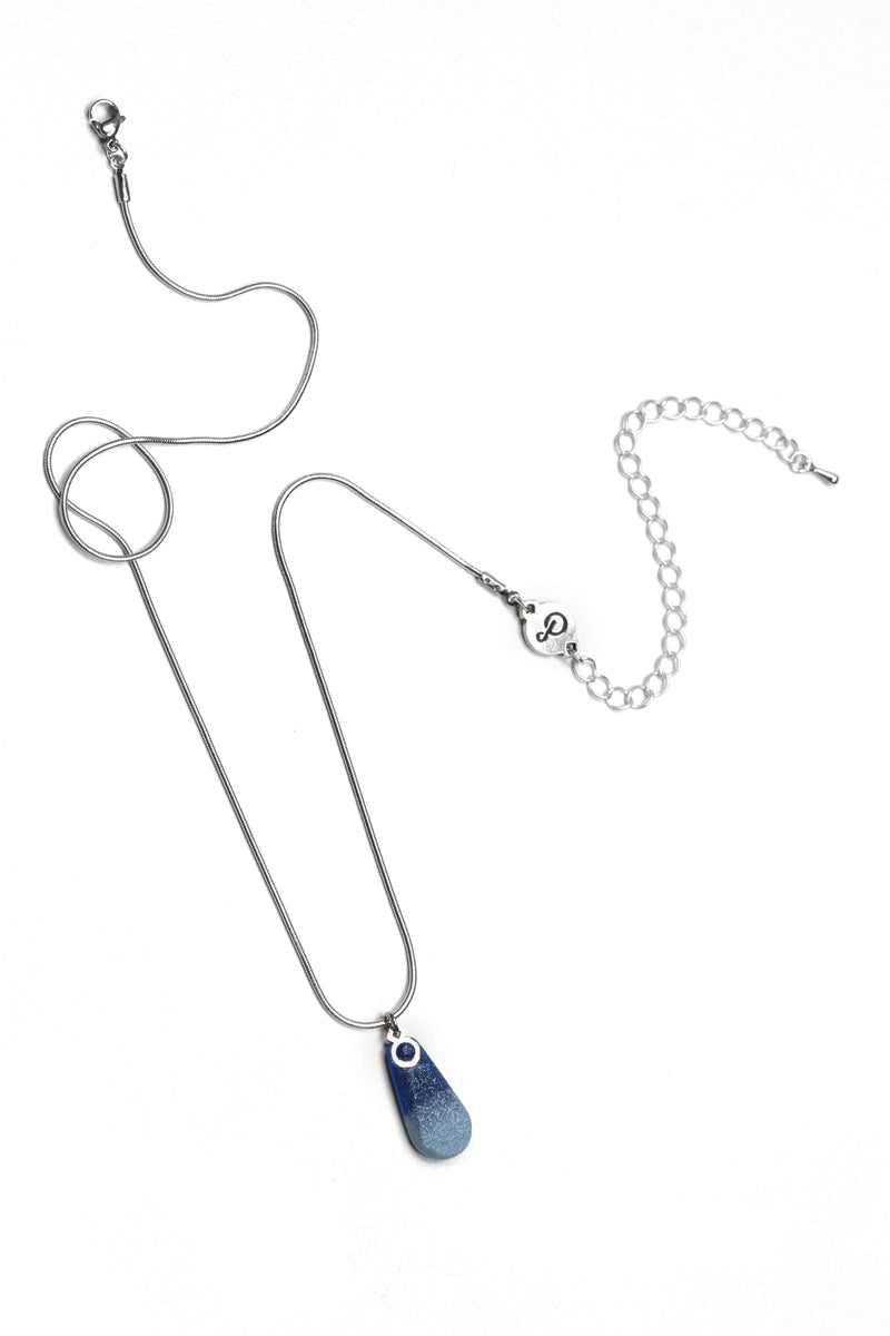 un collier à longueur réglable en résine durable et acier inoxydable hypoallergénique de couleur bleu indigo.
