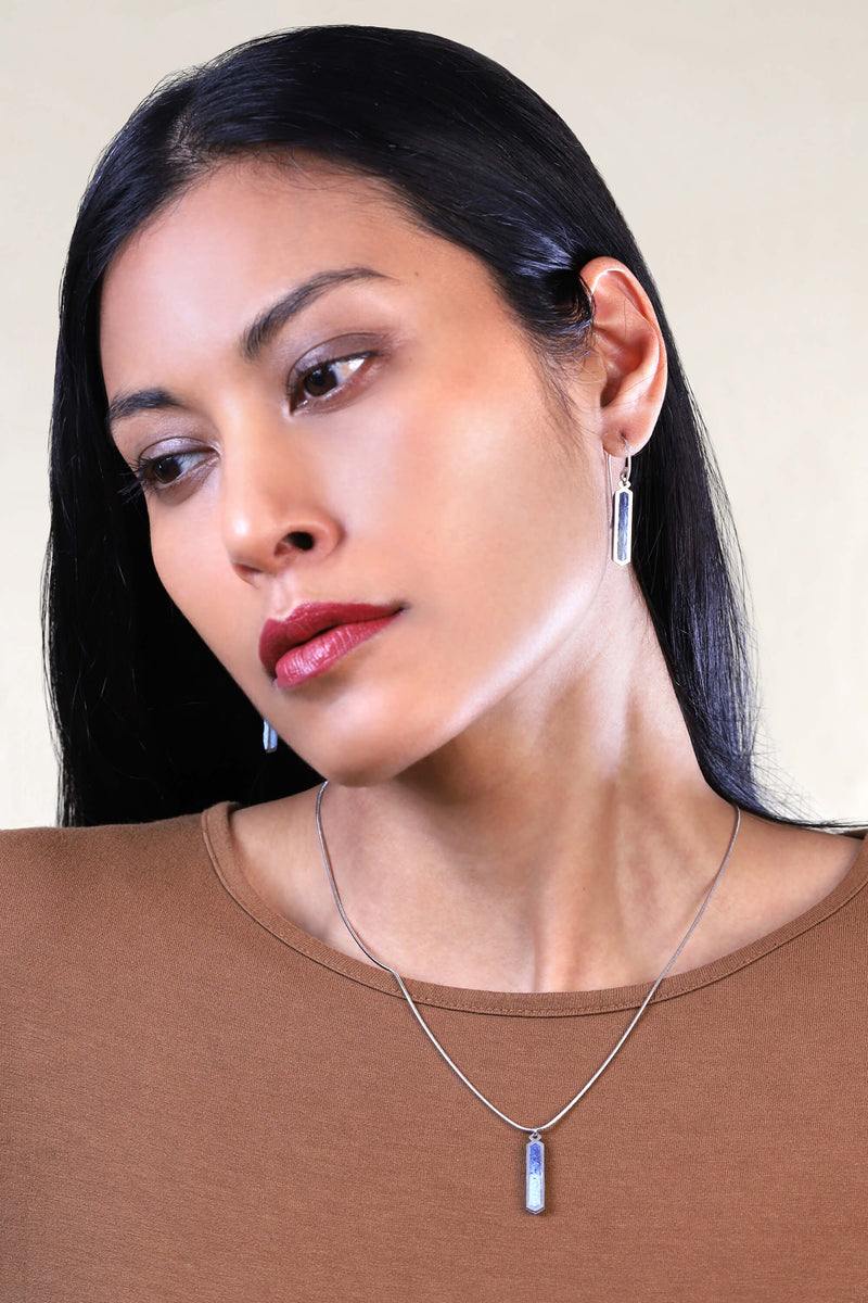 Modèle de mode féminine portant le collier Solstice à longueur réglable en résine durable de couleur indigo et chaîne en acier inoxydable hypoallergénique, fabriqué à la main.