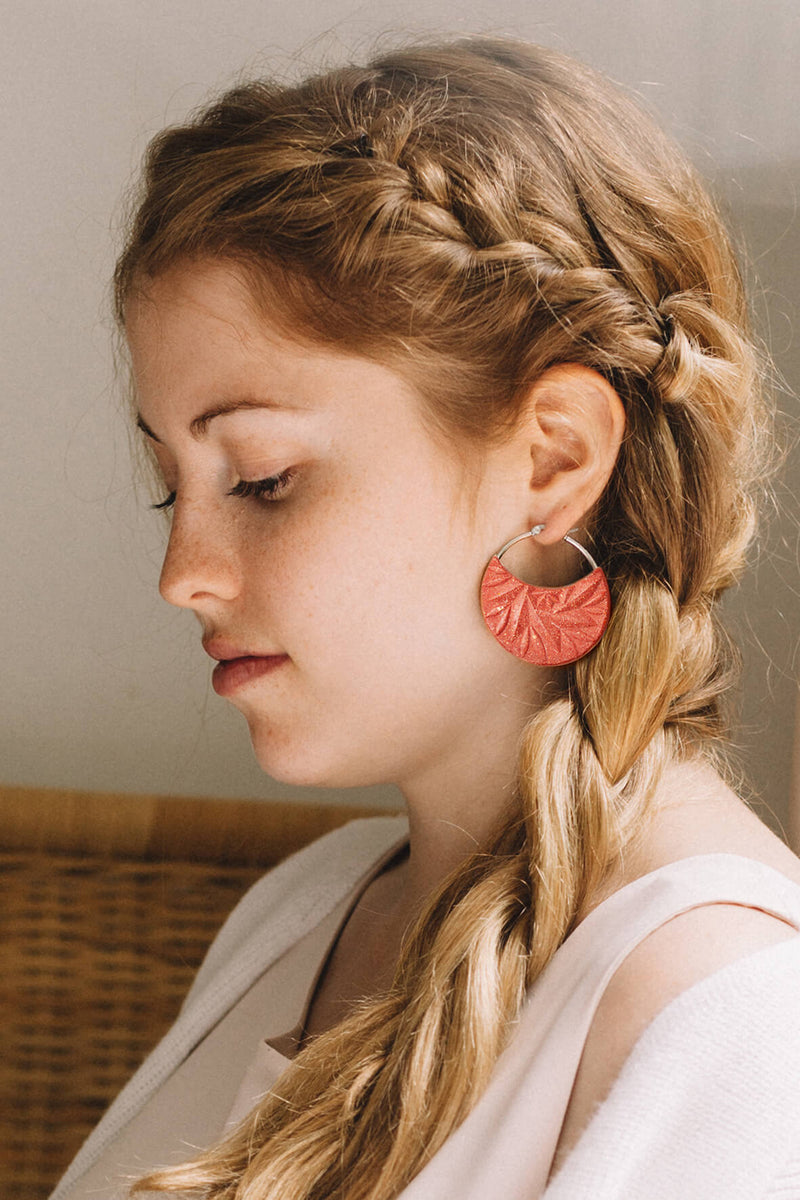 fashion model wearing Séléné earrings, Bijoux Pépine's hypoallergenic luxury hoops in coral red