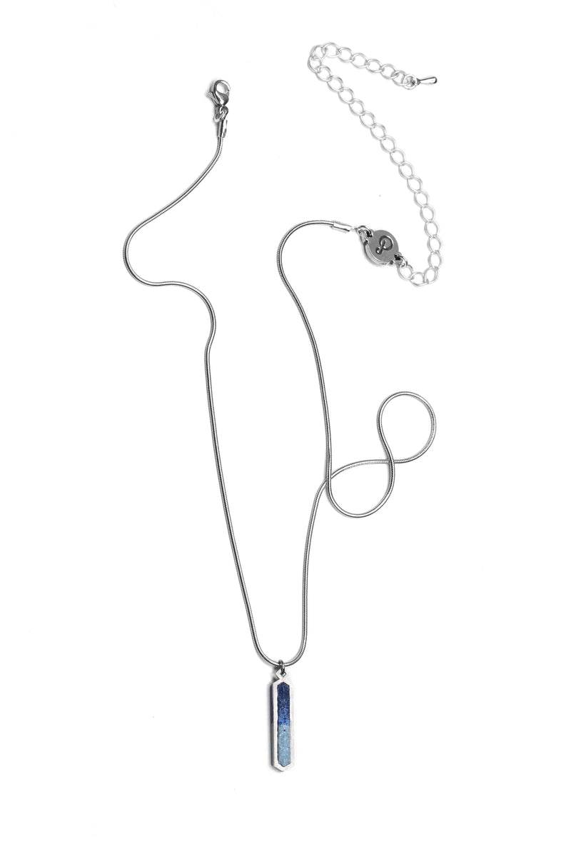 le collier Solstice à longueur réglable en résine durable de couleur indigo et chaîne en acier inoxydable hypoallergénique, fabriqué à la main.