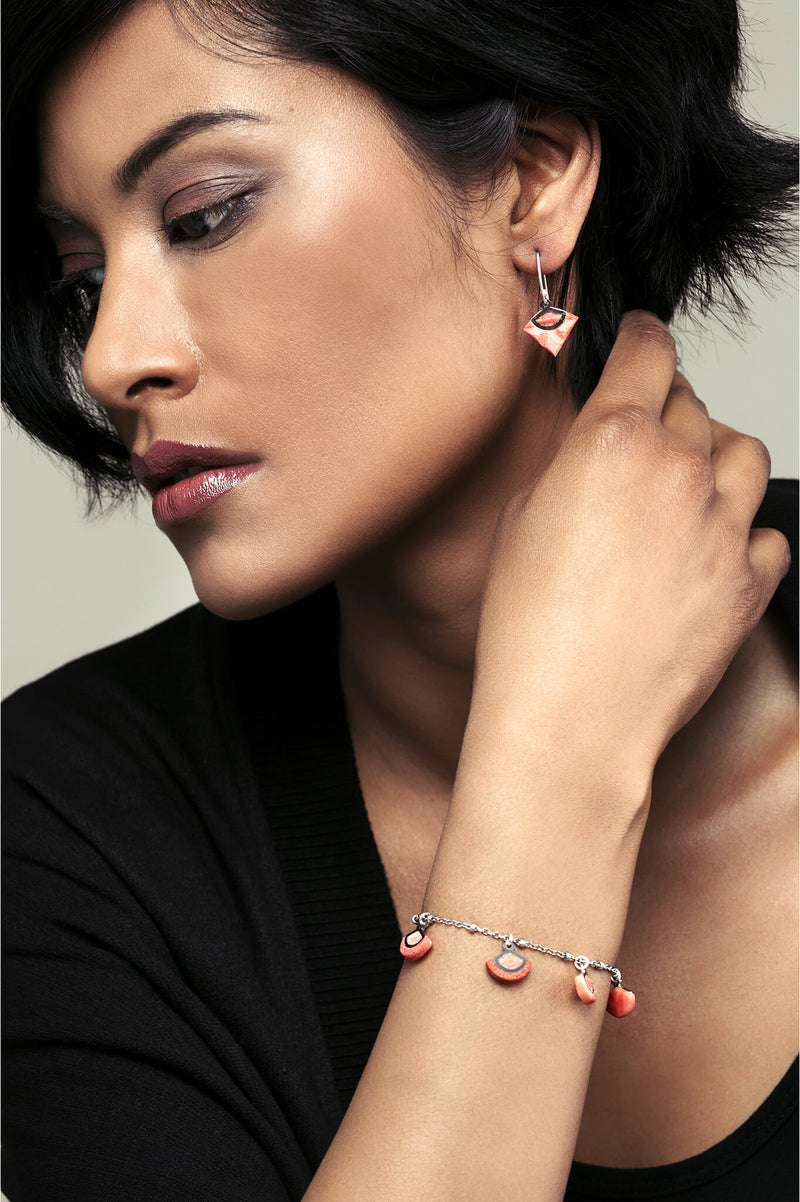 female model wearing St-Jacques luxury bracelet in coral red, handmade by Bijoux Pépine