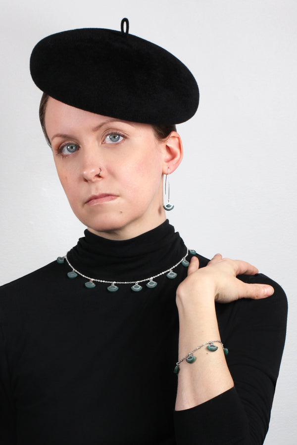 Fashion model female wearing St-Jacques, light shell-shaped earrings shape handmade process with green forest sustainable resin and hypoallergenic stainless steel hook