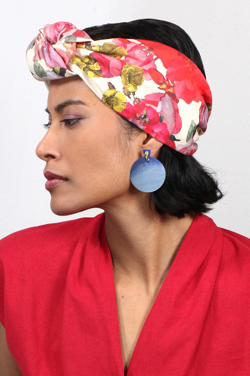 Fashion model female wearing Ulu, contemporary huge statement studs in blue indigo sustainable resin and gold leaf 24 carats