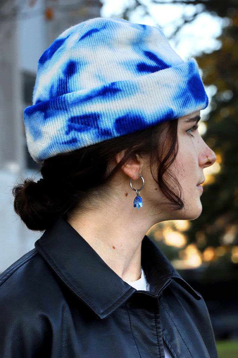 Jeune femme modèle portant Lys, boucles d'oreilles pendantes en forme de fleur en bleu indigo par Bijoux Pépine, procédé artisanal.