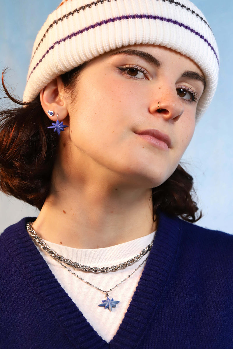 Jeune femme mannequin portant  Etoile du Berger, collier en forme d'étoile fait main en résine bleu indigo et acier inoxydable hypoallergénique